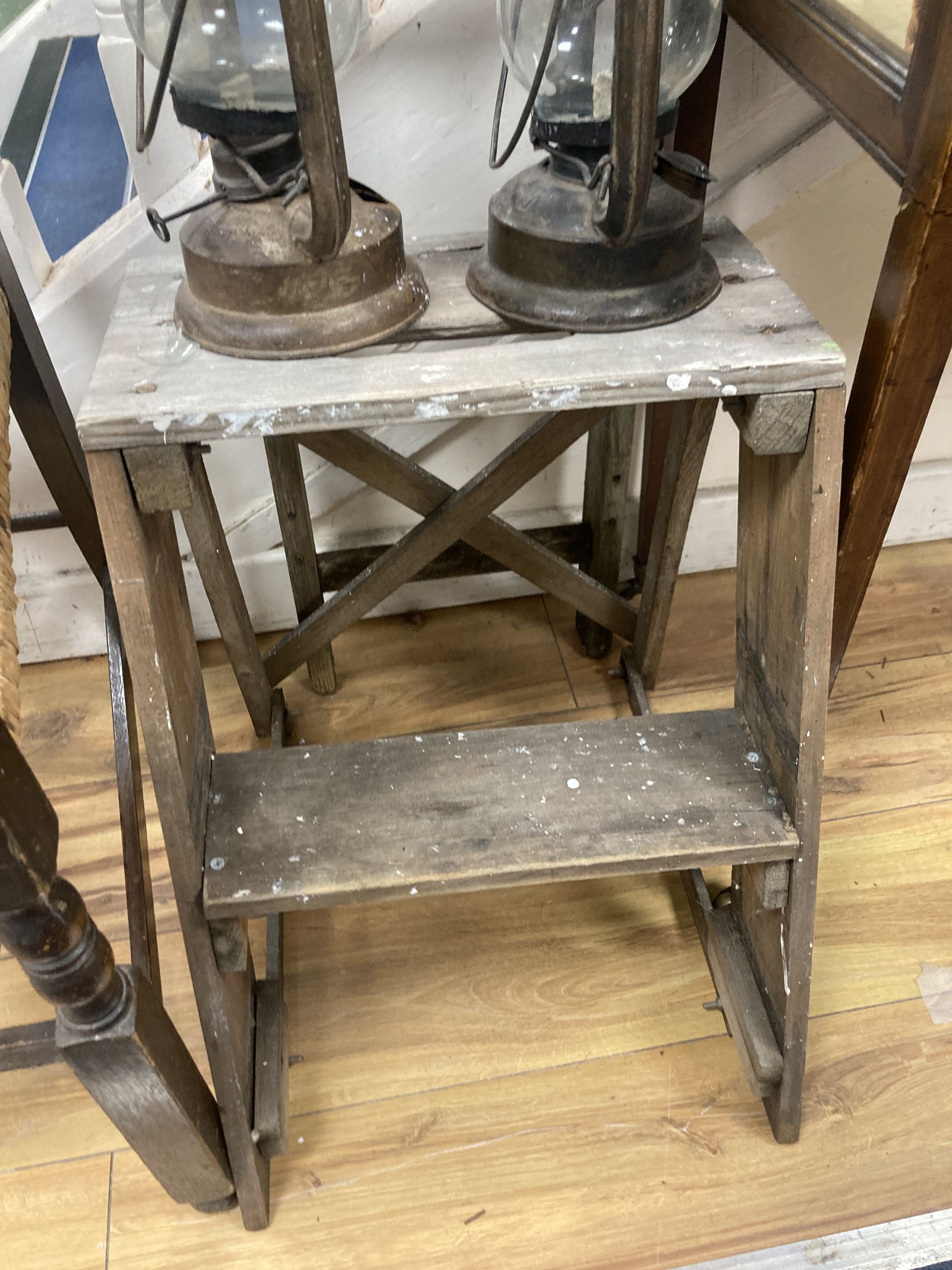 A rush seated beech elbow chair, a vintage five tread step ladder, a similar pine step stool and two oil lamps